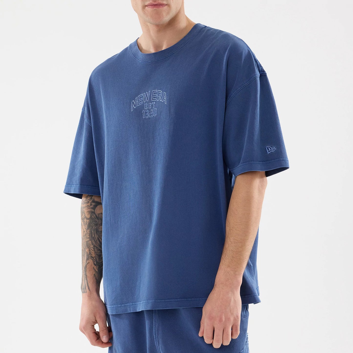 The model is wearing this New Era Street Archived Oversized T-Shirt in blue. 5