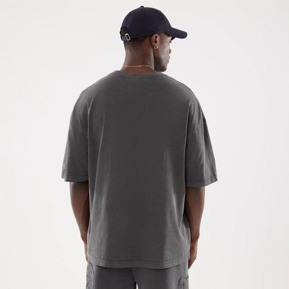 New Era Graphic Street Archived Washed Black Oversized T-Shirt, rear view showing the oversized fit with a wide neckline, dark washed colour and a small debossed New Era logo on the left sleeve near the hem.