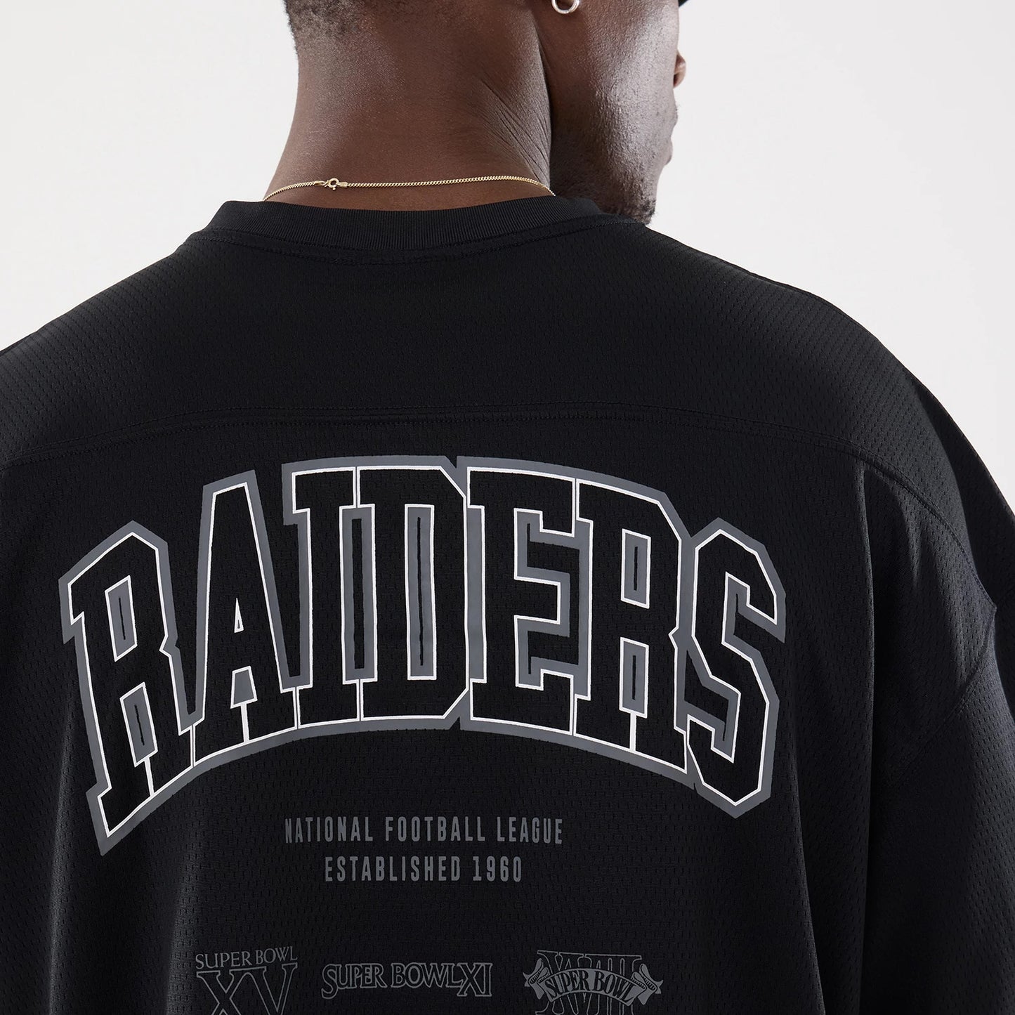 The model is wearing this NFL Raiders Wear Black Las Vegas Raiders Mesh Oversized T-Shirt in black. 7