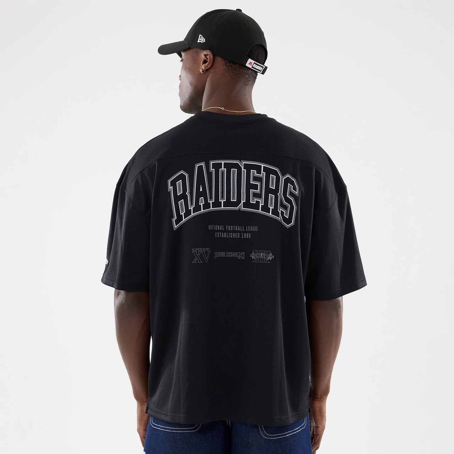 The model is wearing this NFL Raiders Wear Black Las Vegas Raiders Mesh Oversized T-Shirt in black. 2