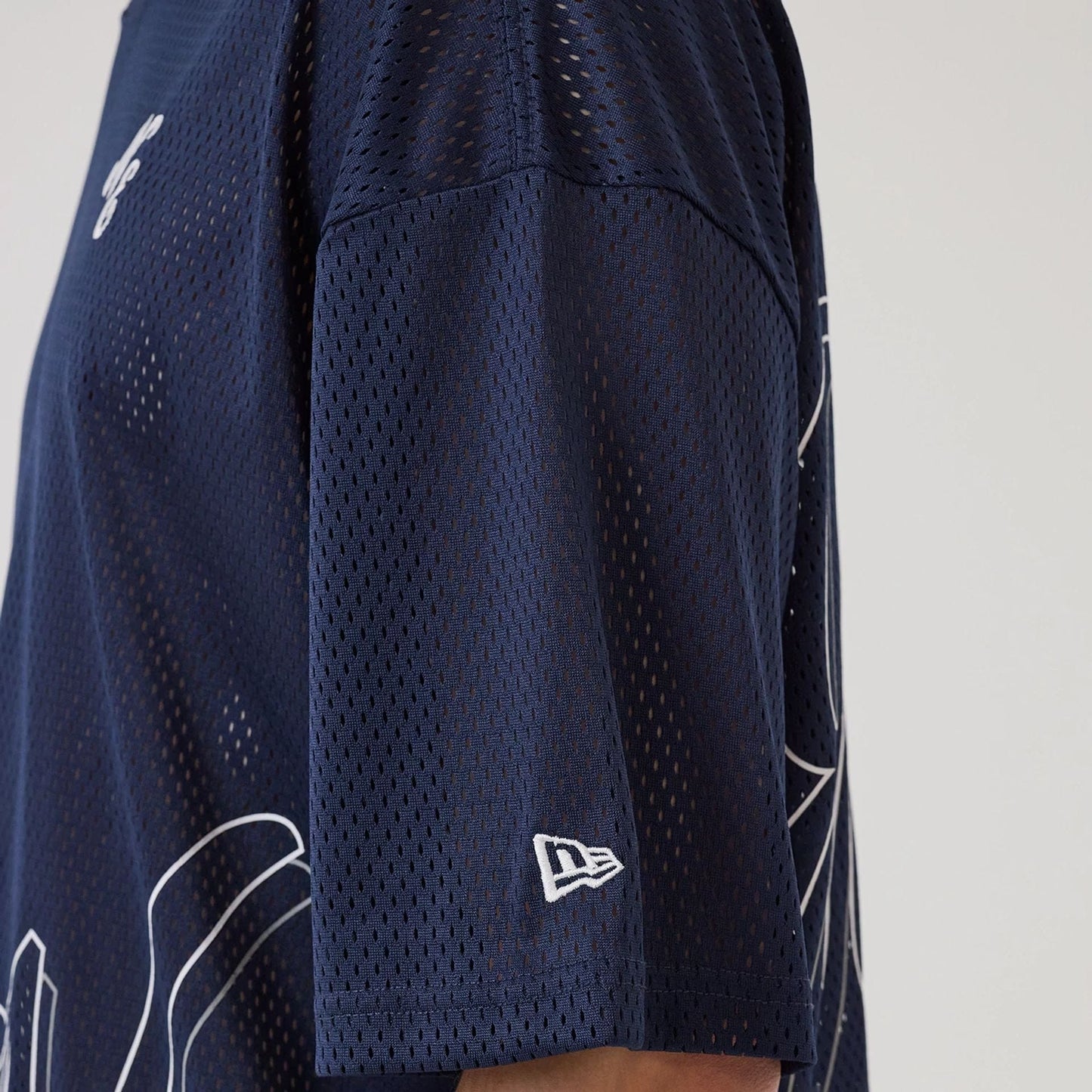 The model is wearing this New Era Mix League Oversized Mesh T-Shirt in blue. 7