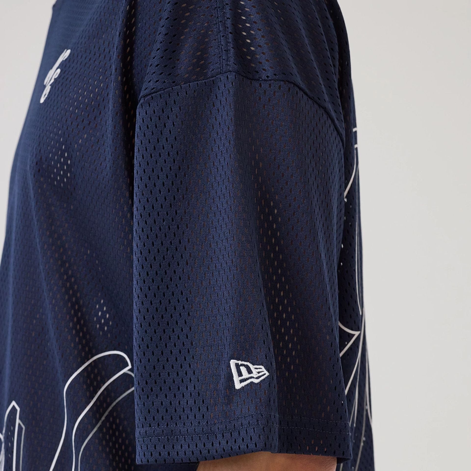 The model is wearing this New Era Mix League Oversized Mesh T-Shirt in blue. 7