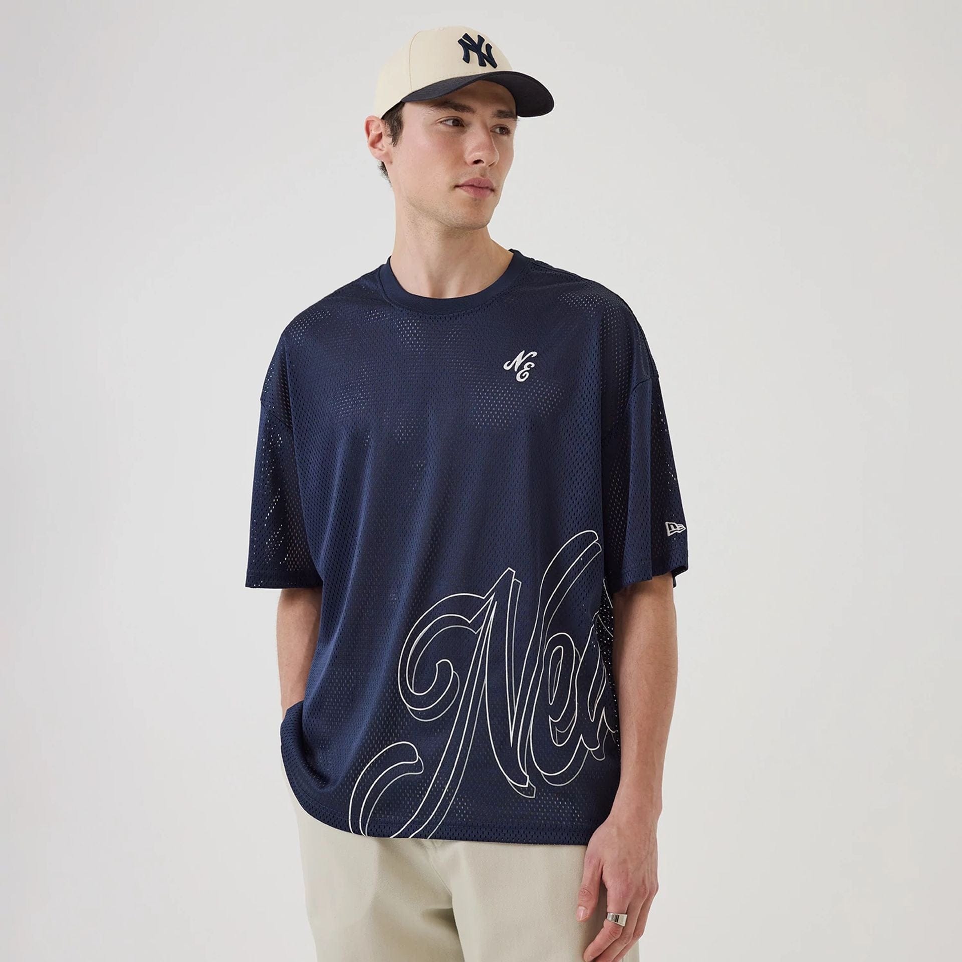 The model is wearing this New Era Mix League Oversized Mesh T-Shirt in blue. 1
