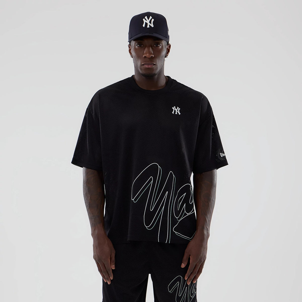 New York Yankees MLB Mix League Black Oversized Mesh T-Shirt, front view showing the large white “NY” logo on the chest, short sleeves with a raised logo on the left, and bold white lettering across the lower half.
