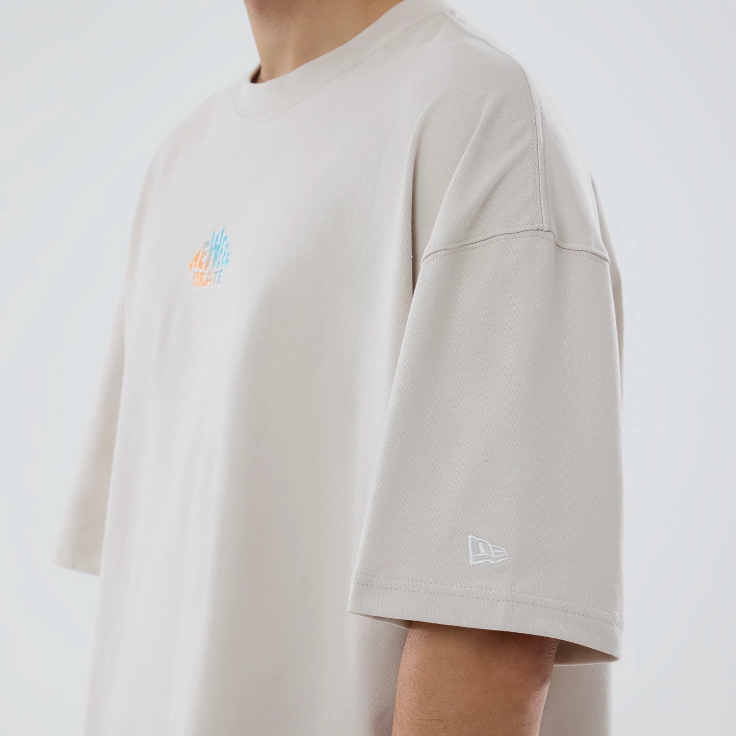The model is wearing this New Era Skate Is Life Graphic Oversized T-Shirt in Cream. 5