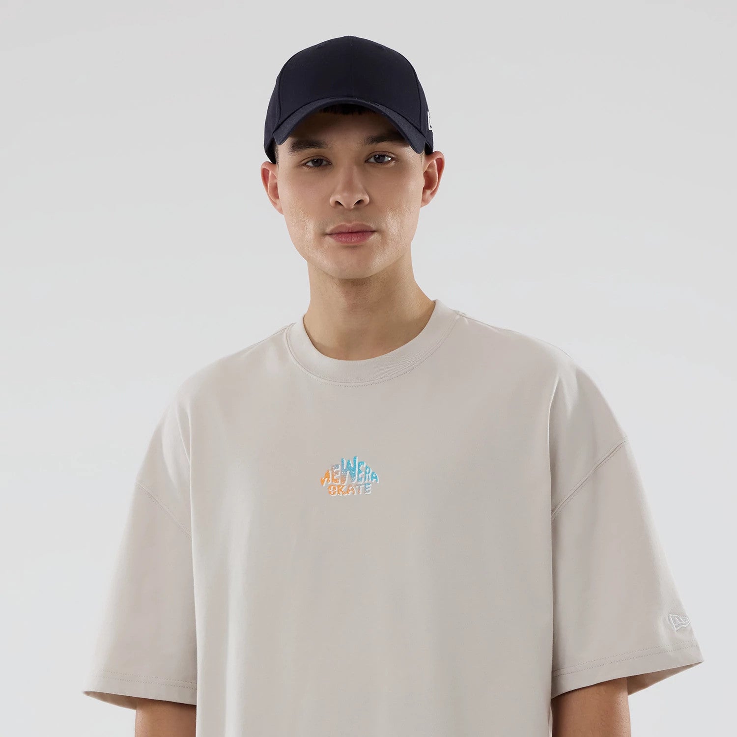 The model is wearing this New Era Skate Is Life Graphic Oversized T-Shirt in Cream. 6