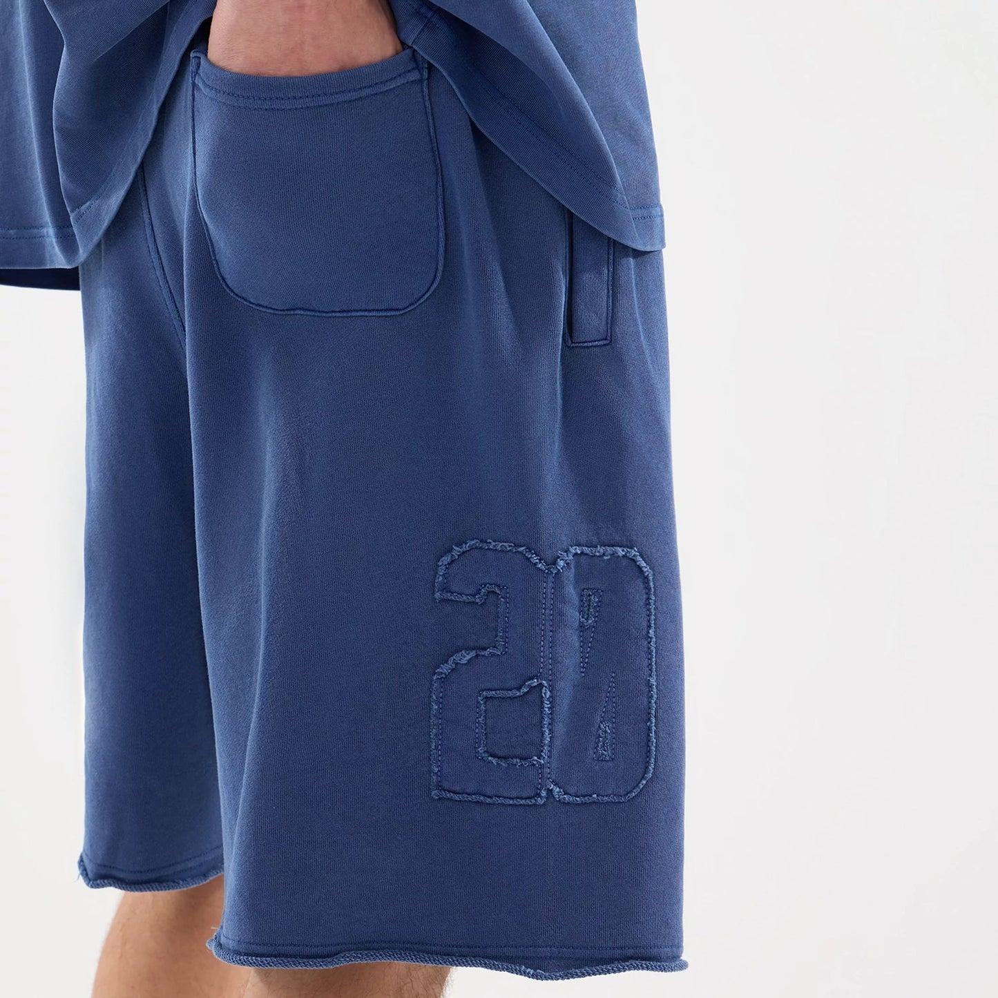 The model is wearing this New Era Street Archived Oversized Shorts in blue. 7