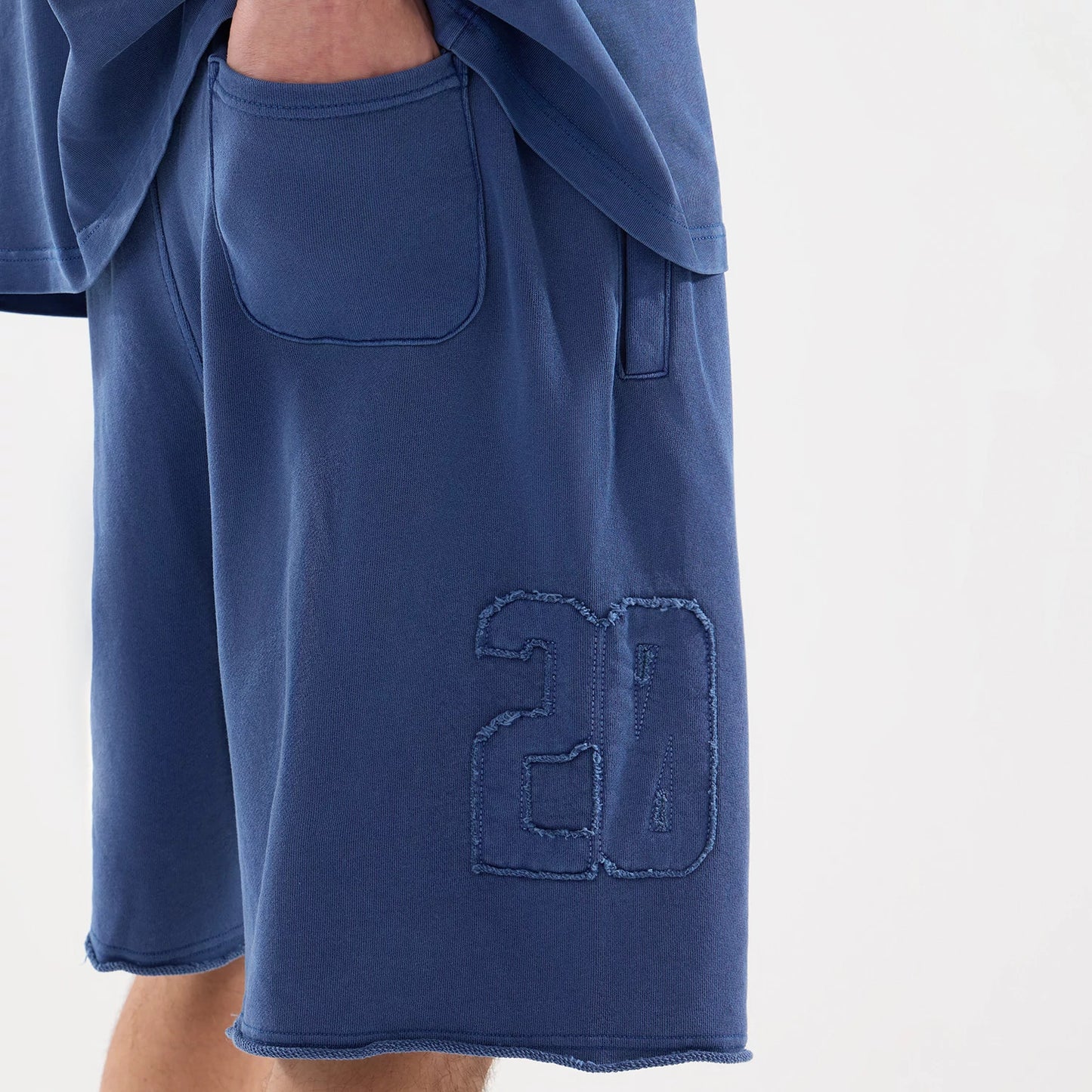 The model is wearing this New Era Street Archived Oversized Shorts in blue. 7