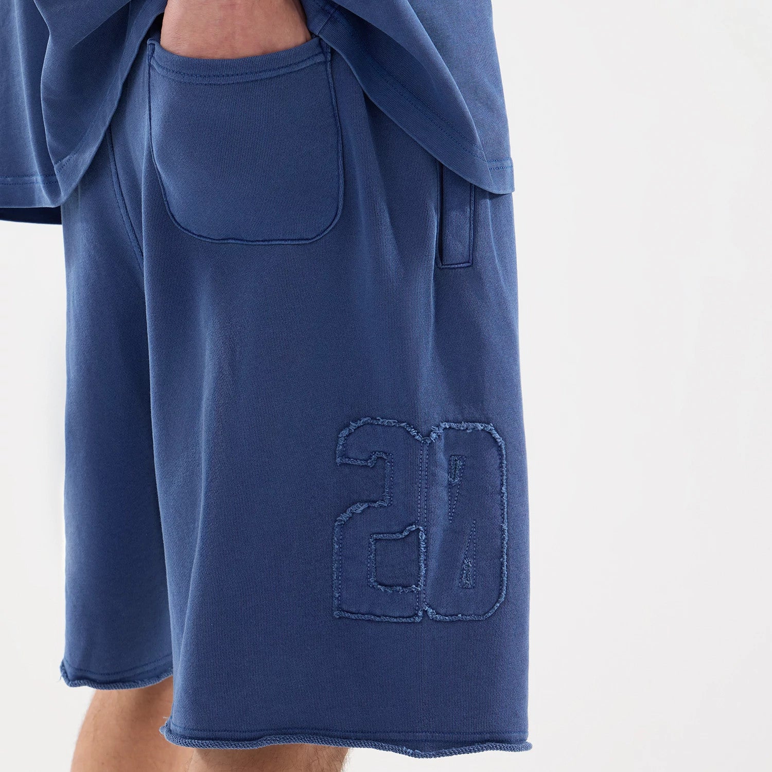 The model is wearing this New Era Street Archived Oversized Shorts in blue. 7