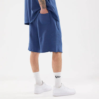 The model is wearing this New Era Street Archived Oversized Shorts in blue. 2