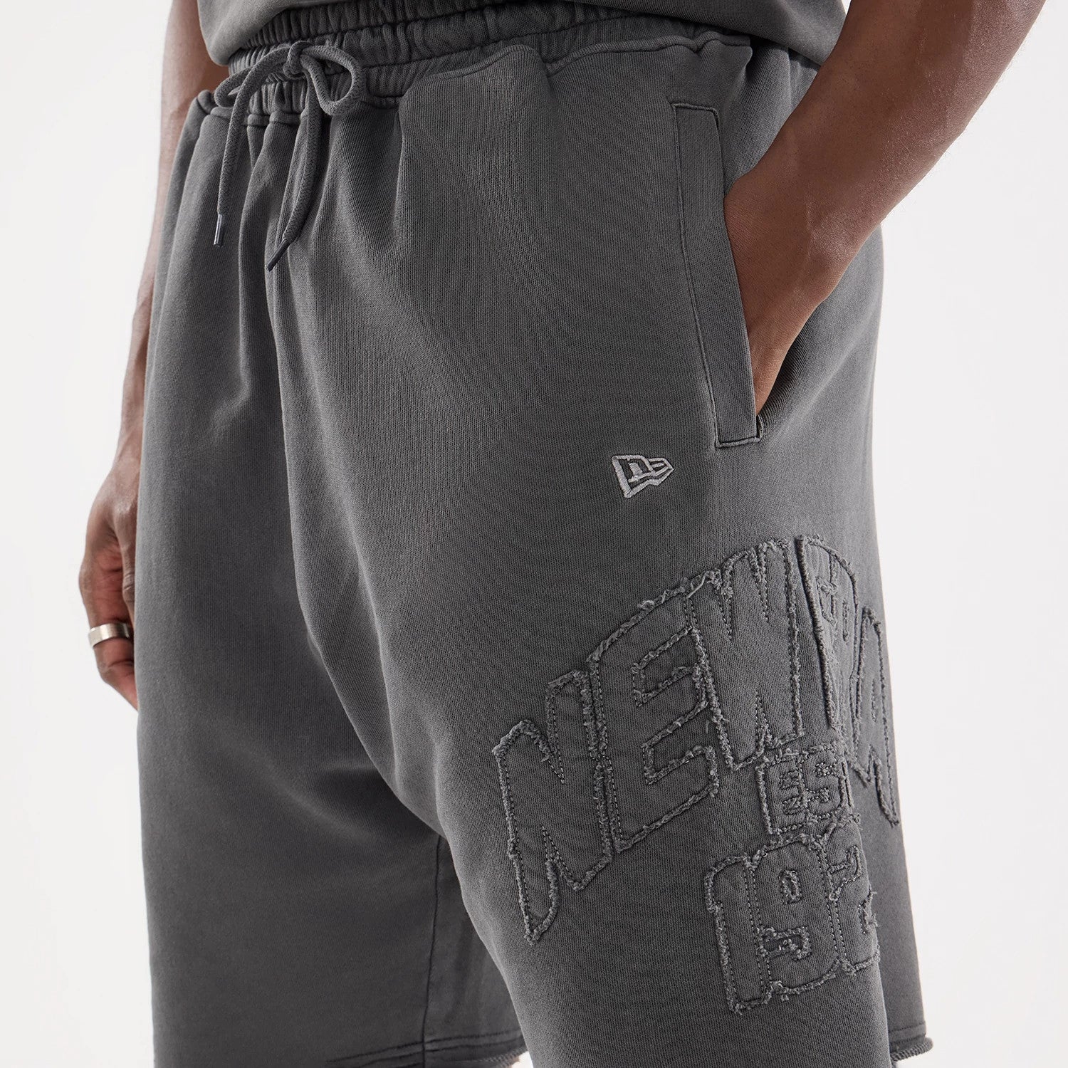 The model is wearing this New Era Street Archived Oversized Shorts in black. 5