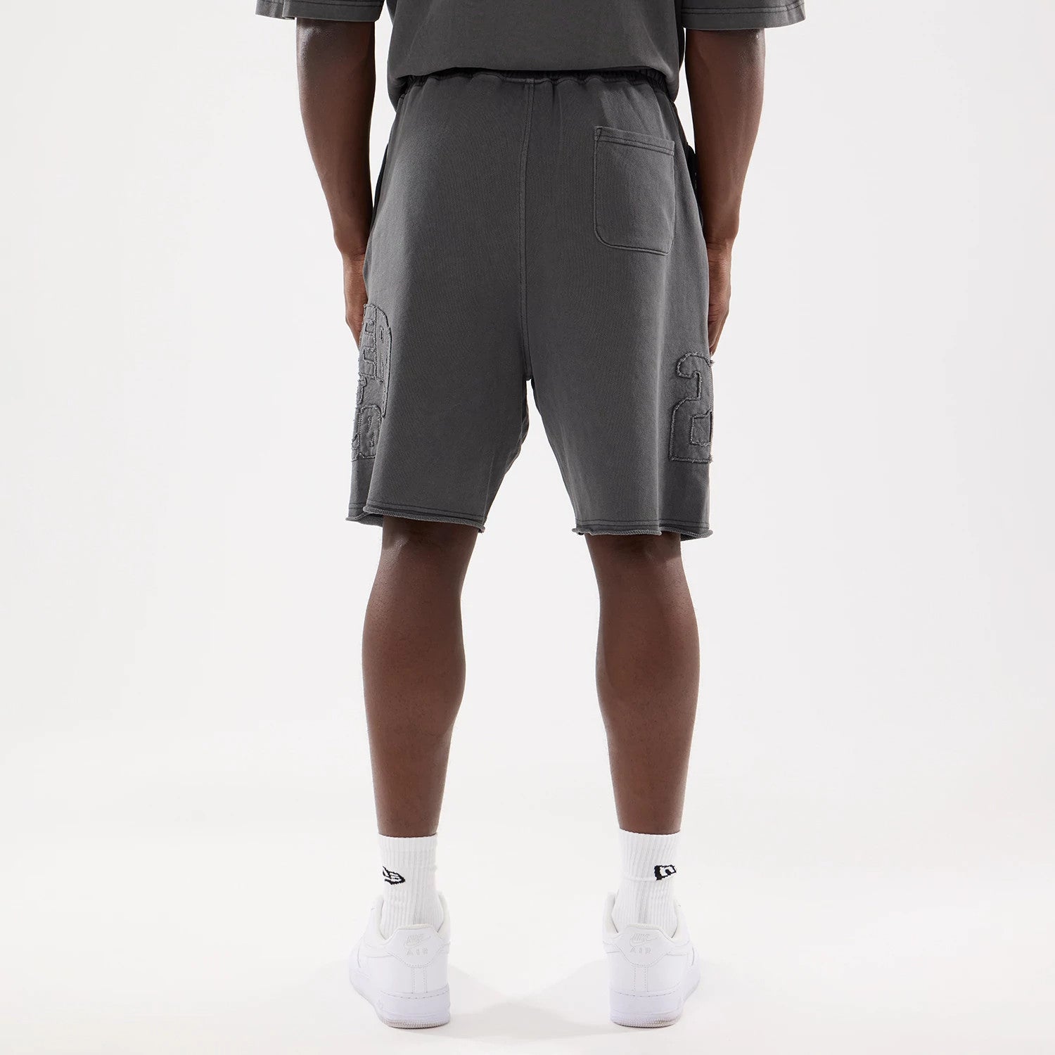 The model is wearing this New Era Street Archived Oversized Shorts in black. 2