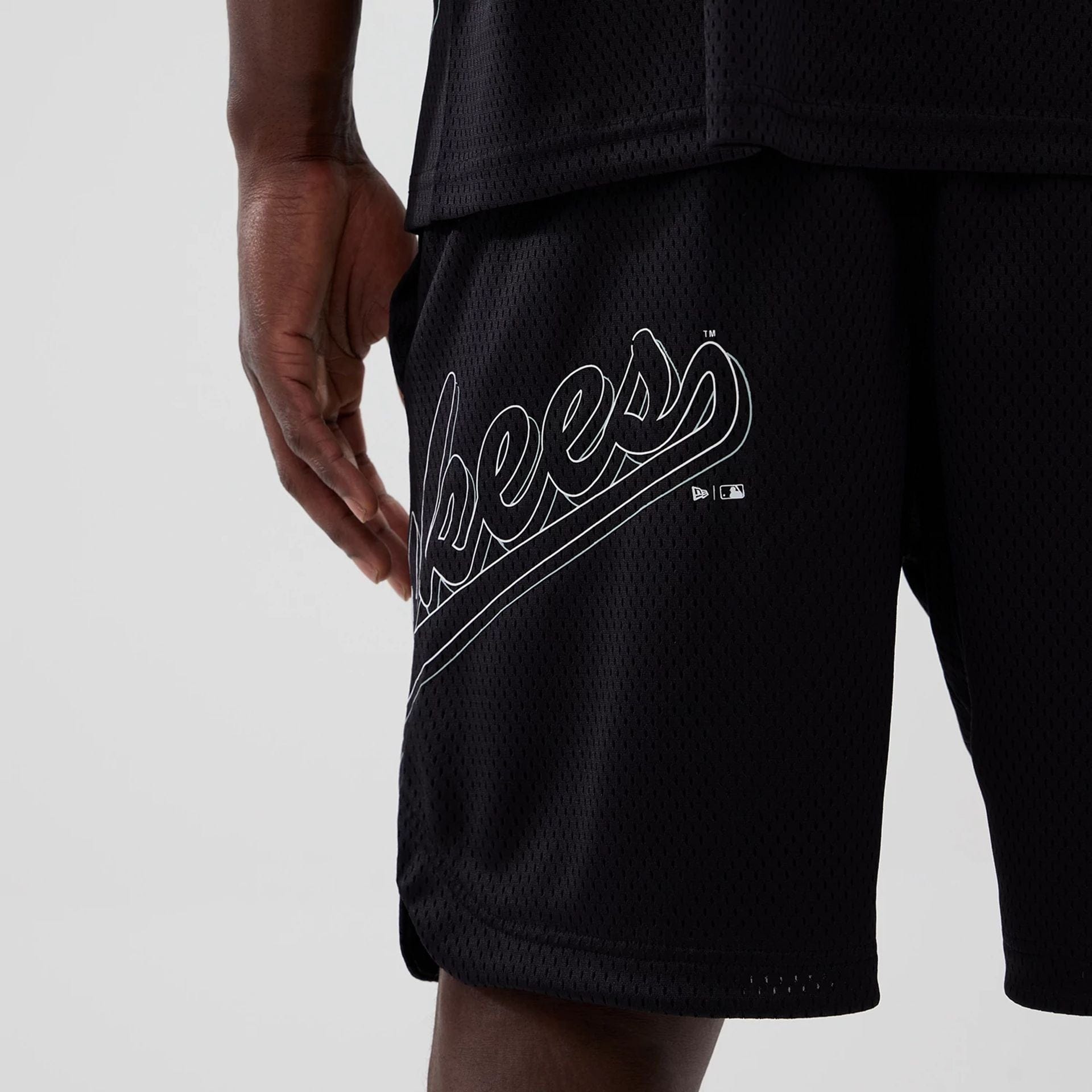 The model is wearing this MLB Mix League New York Yankees Oversized Mesh Shorts in black. 3