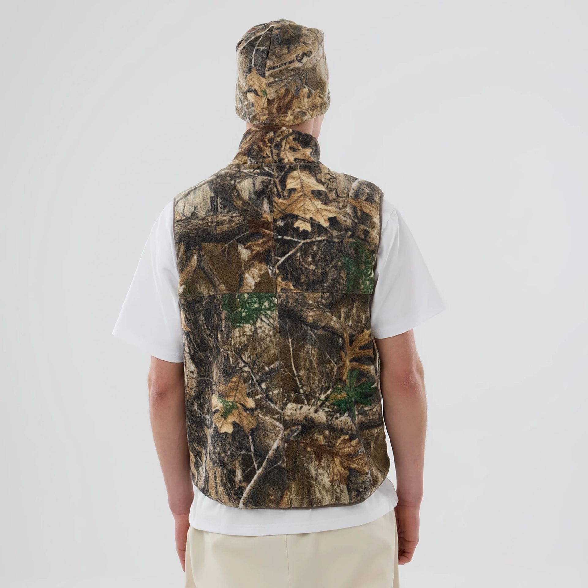The model is wearing this Thisisneverthat X New Era Revolution Fleece Vest in Real Tree. 2