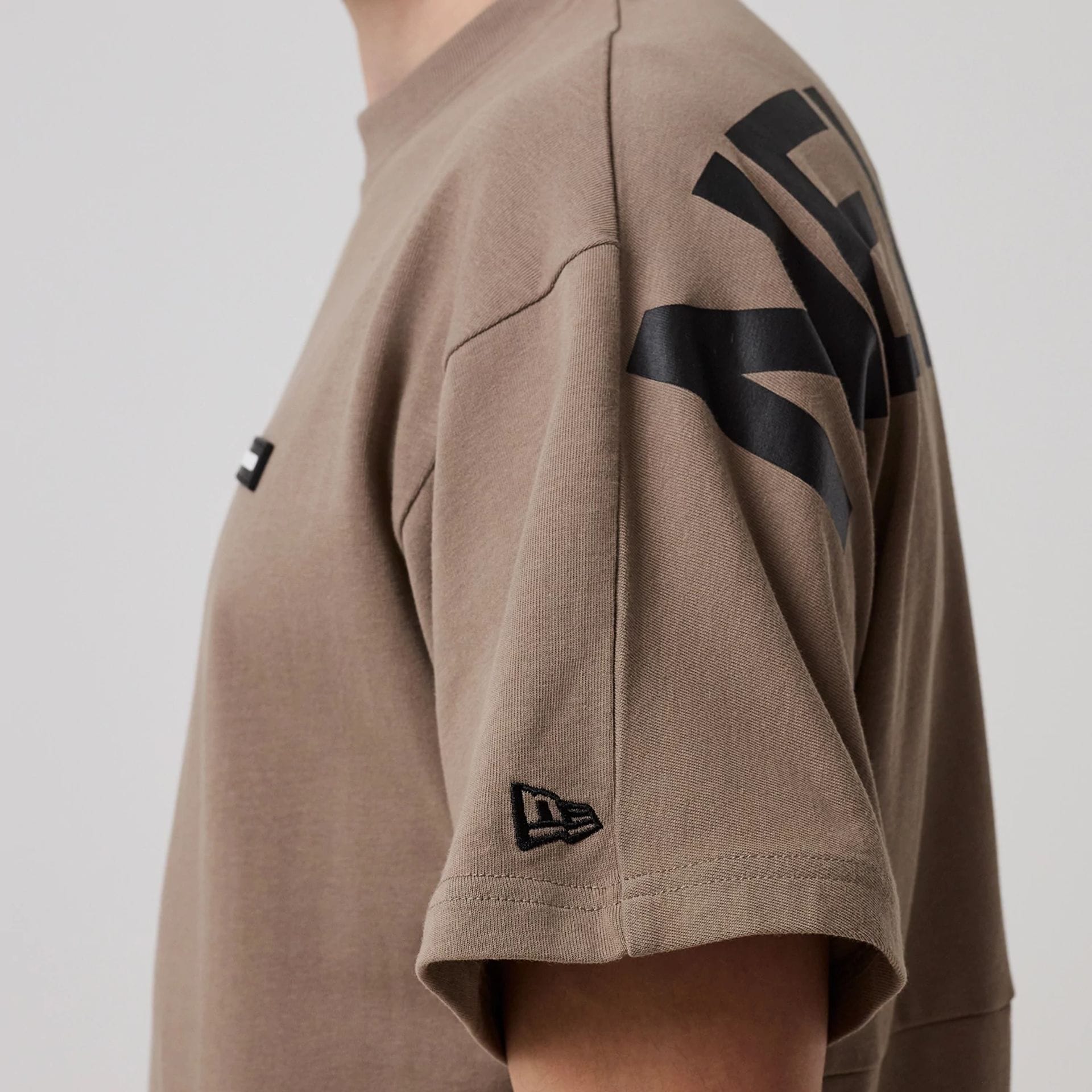 The model is wearing this New Era Distressed T-Shirt in Brown. 5