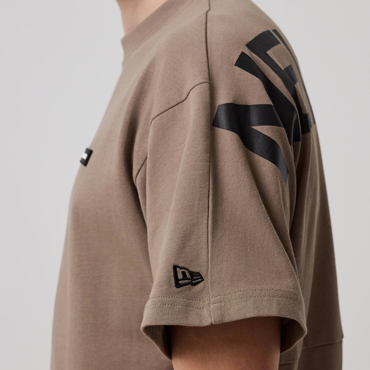 The model is wearing this New Era Distressed T-Shirt in Brown. 5