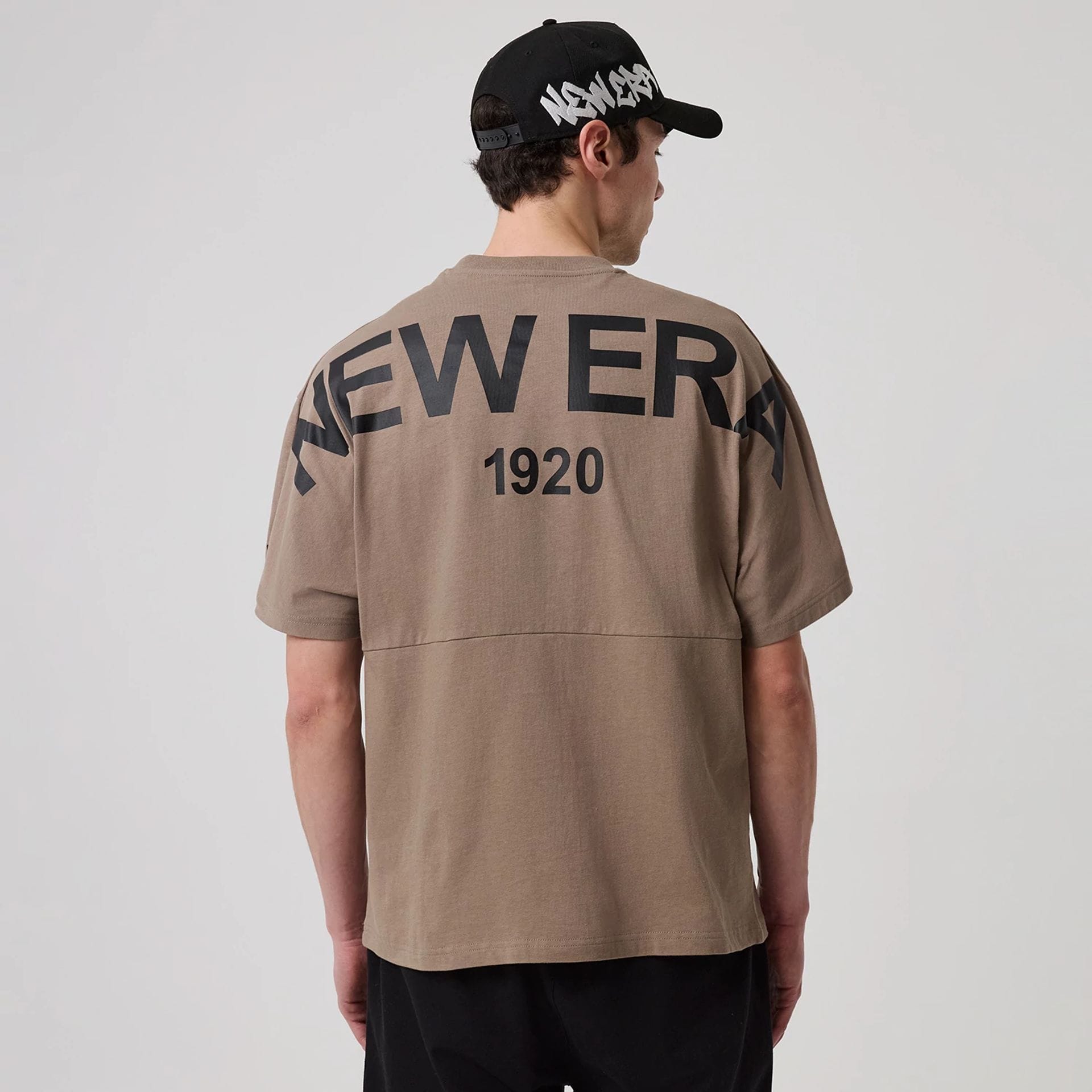The model is wearing this New Era Distressed T-Shirt in Brown. 2