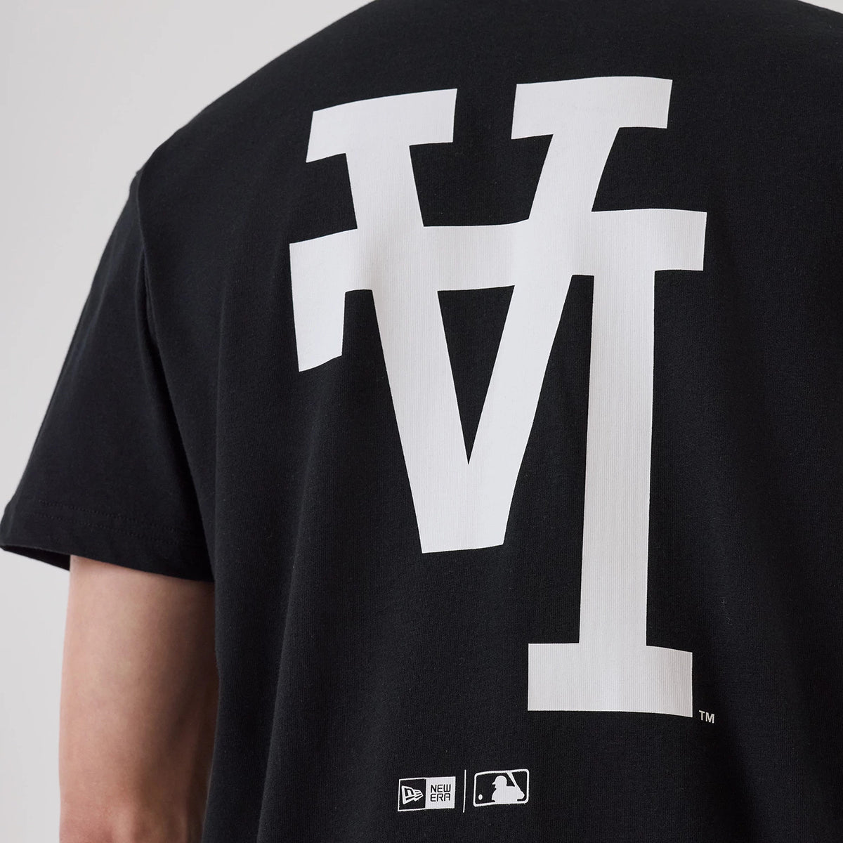 LA Dodgers MLB Upside Down Black T-Shirt, rear view showing a large white upside-down LA graphic in the centre, with small embroidered New Era and MLB logos at the bottom near the hem.