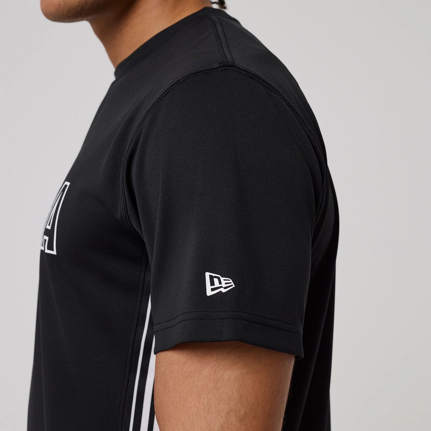 The model is wearing this New Era Mesh T-Shirt in black. 4
