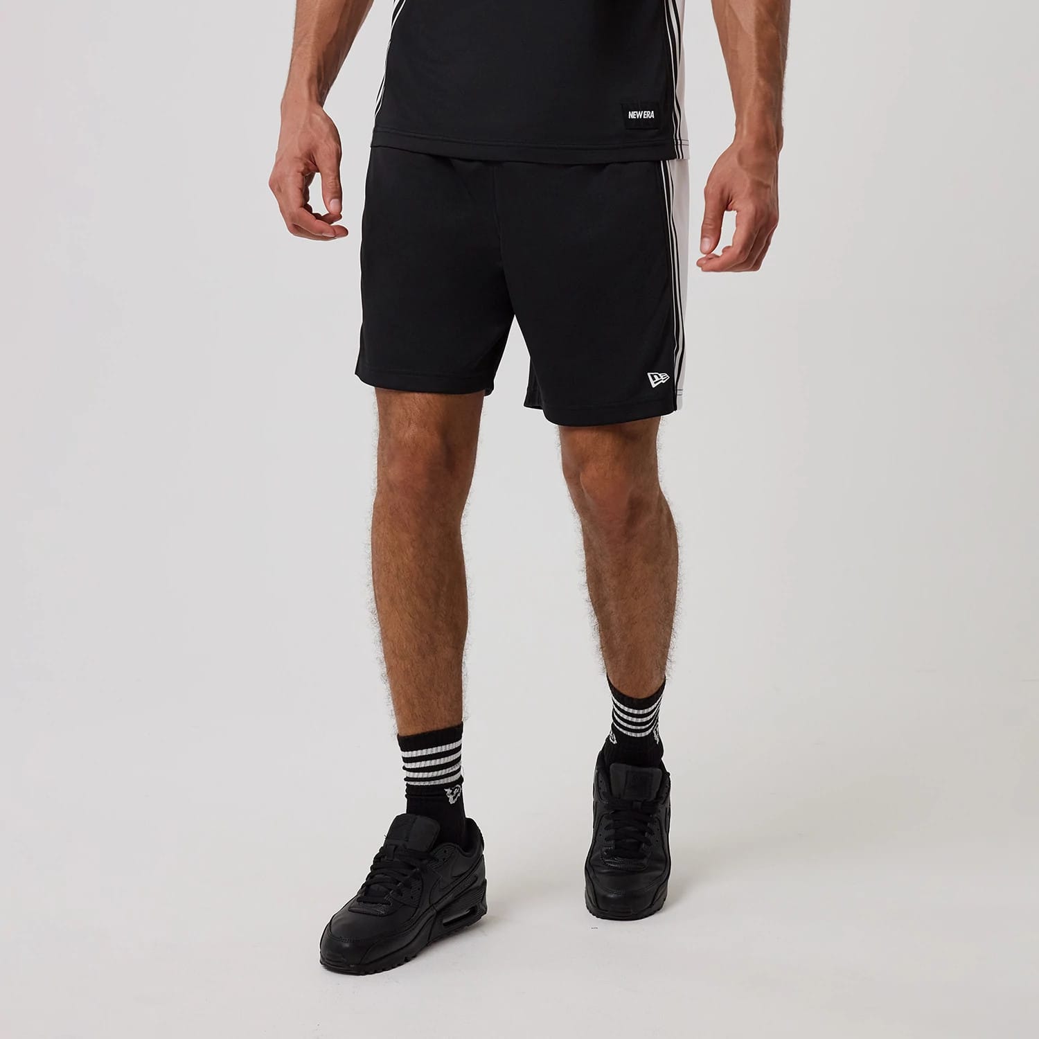 The model is wearing this New Era Mesh Shorts in black. 1