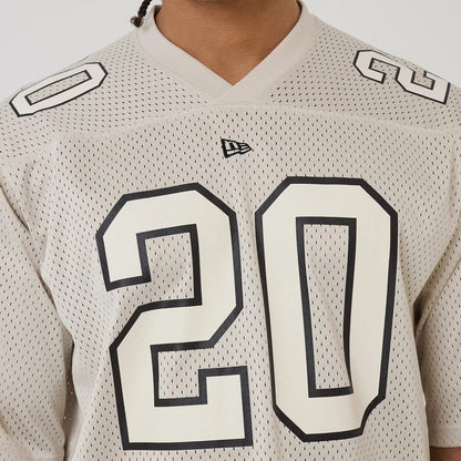 The model is wearing this New Era Mesh Football Short Sleeve Shirt in beige. 4