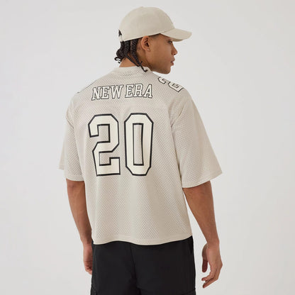 The model is wearing this New Era Mesh Football Short Sleeve Shirt in beige. 2