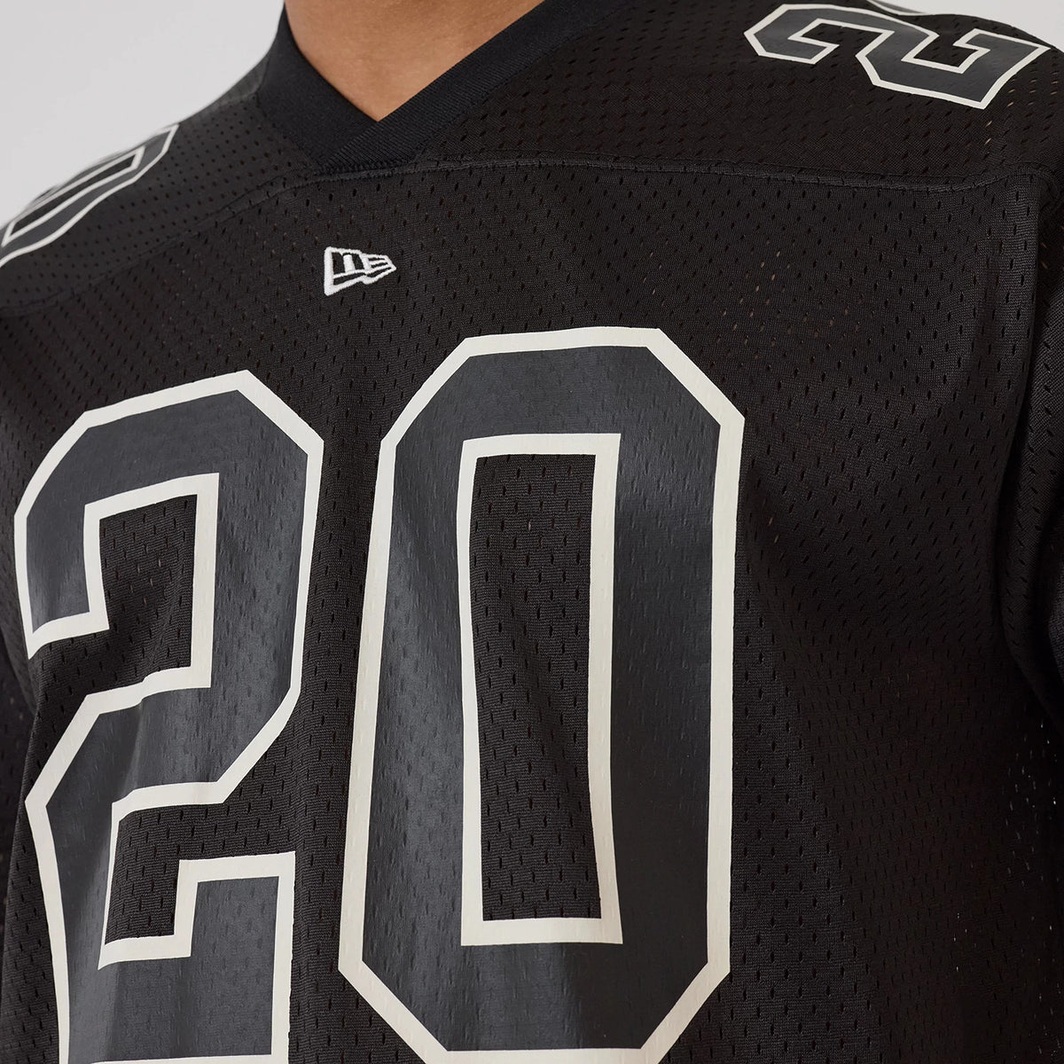 New Era Mesh Football Black Short Sleeve Shirt, close-up view showing the large number 20 in white on a black mesh fabric with a New Era flag logo and contrasting number on the shoulder.