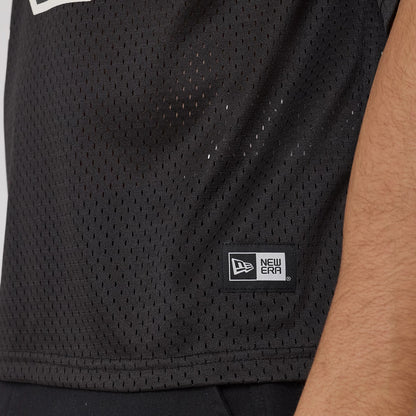 New Era Mesh Football Black Short Sleeve Shirt, side view showing the mesh texture and a New Era flag logo patch near the hem, worn by a model with part of the arm visible.