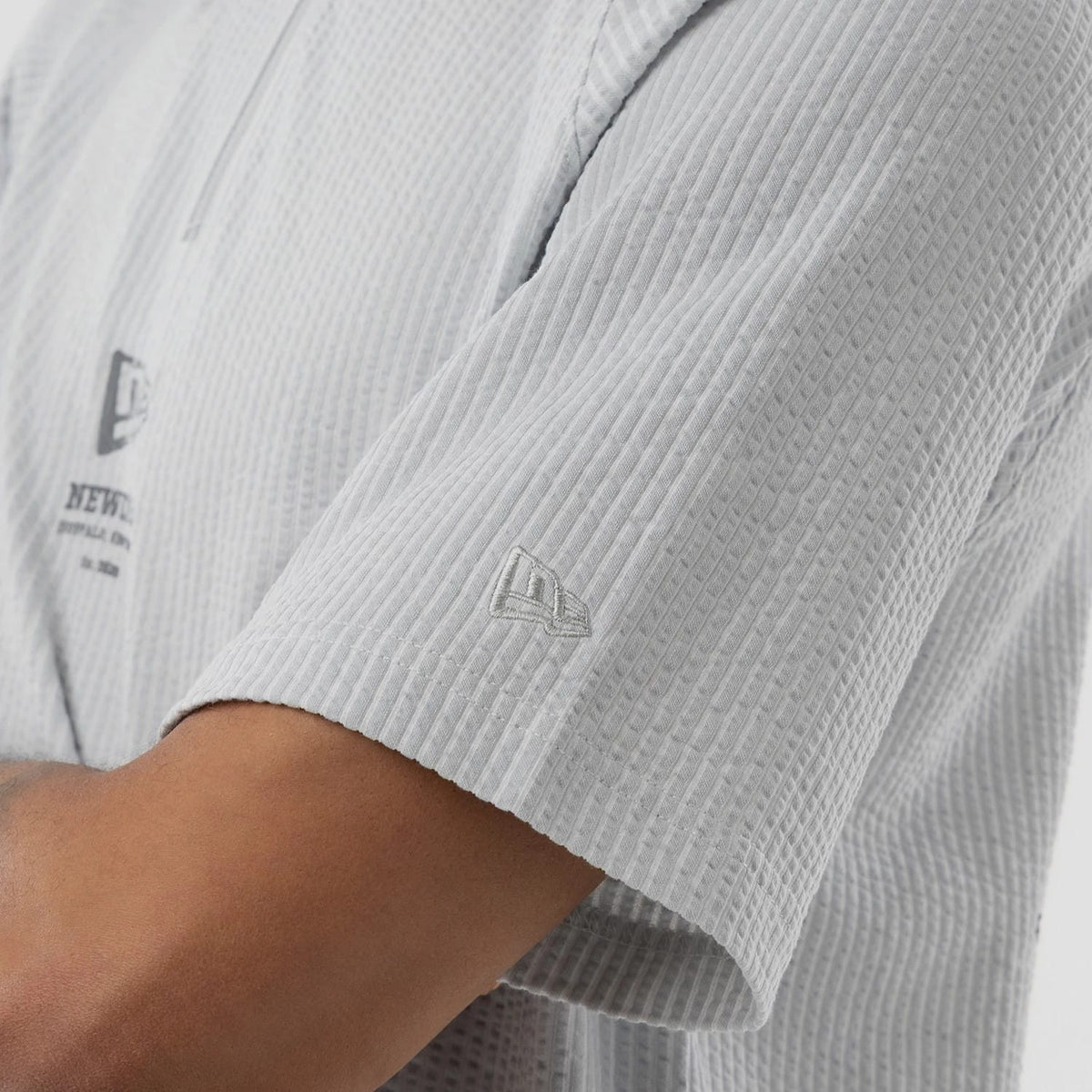The model is wearing this New Era Seersucker Polo T-Shirt in grey. 5