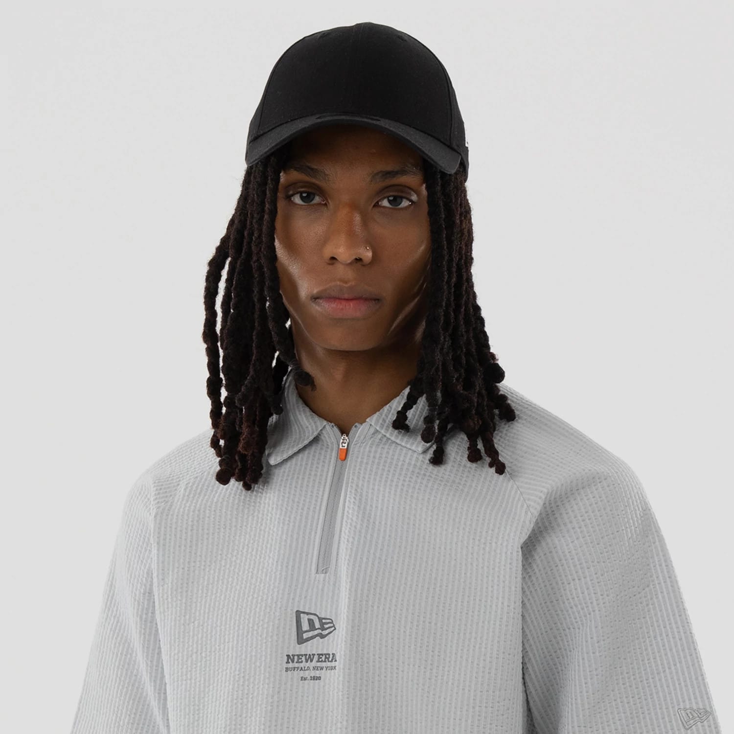 The model is wearing this New Era Seersucker Polo T-Shirt in grey. 7