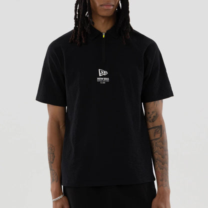 The model is wearing this New Era Seersucker Polo T-Shirt in black. 3