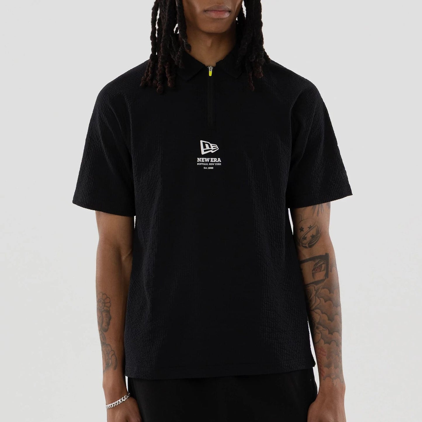 The model is wearing this New Era Seersucker Polo T-Shirt in black. 3