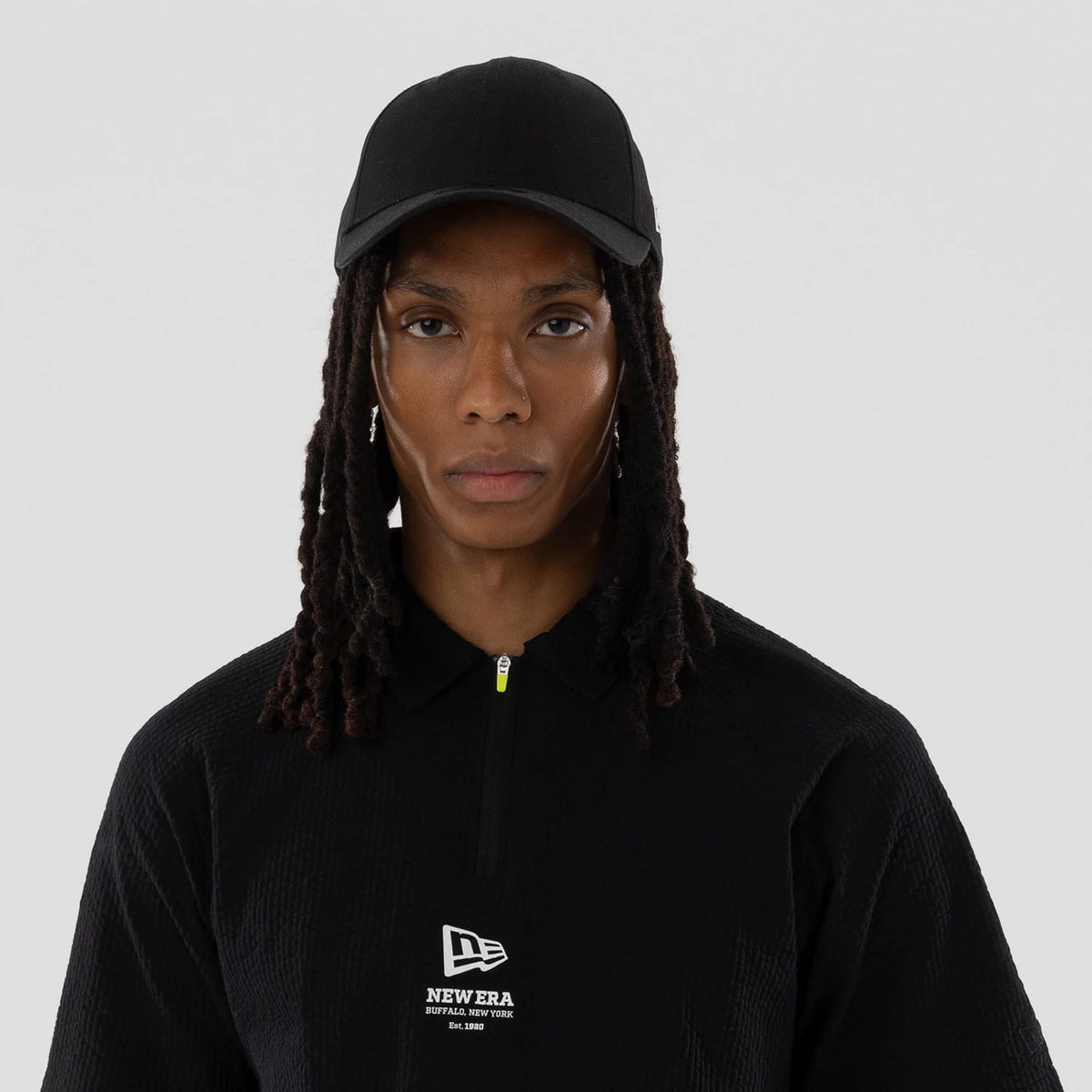 The model is wearing this New Era Seersucker Polo T-Shirt in black. 7
