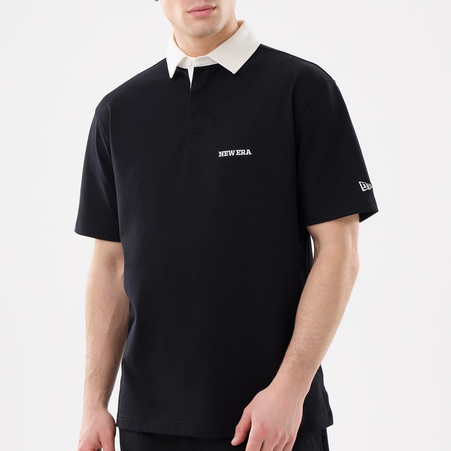 The model is wearing this New Era Short Sleeve Rugby Shirt in black. 3