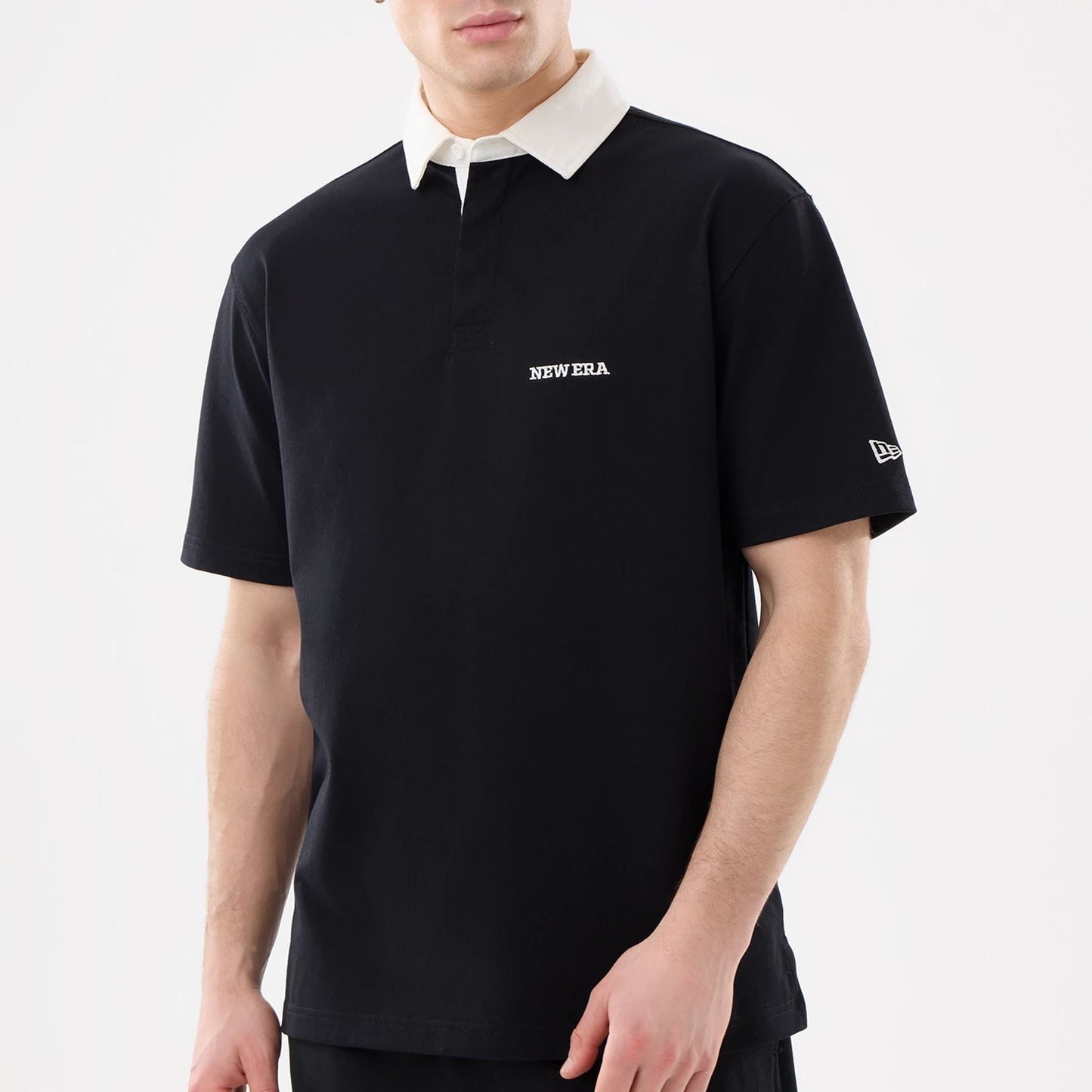 The model is wearing this New Era Short Sleeve Rugby Shirt in black. 3