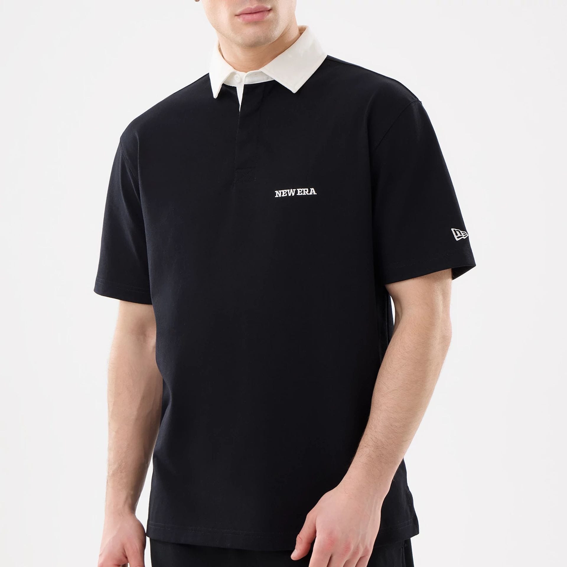 The model is wearing this New Era Short Sleeve Rugby Shirt in black. 3