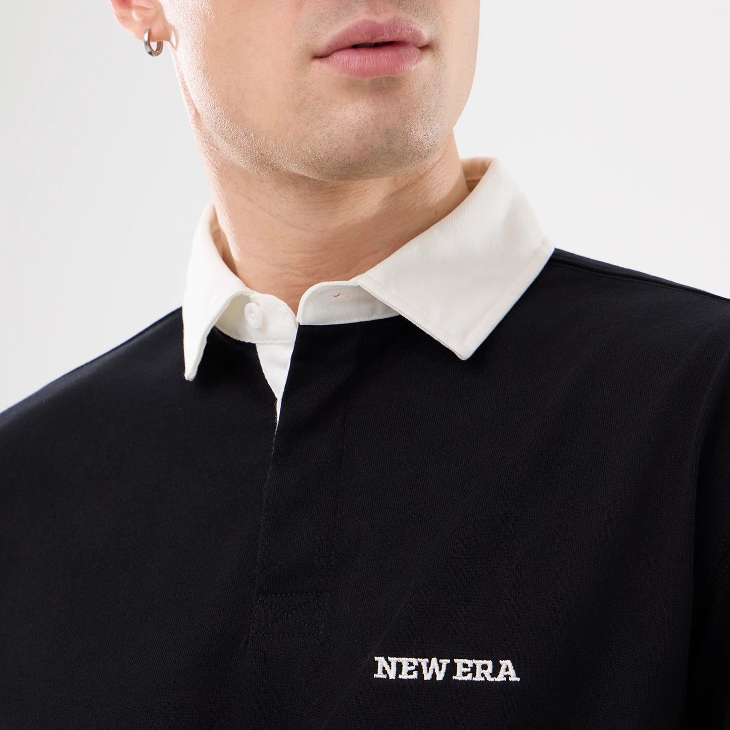 The model is wearing this New Era Short Sleeve Rugby Shirt in black. 4