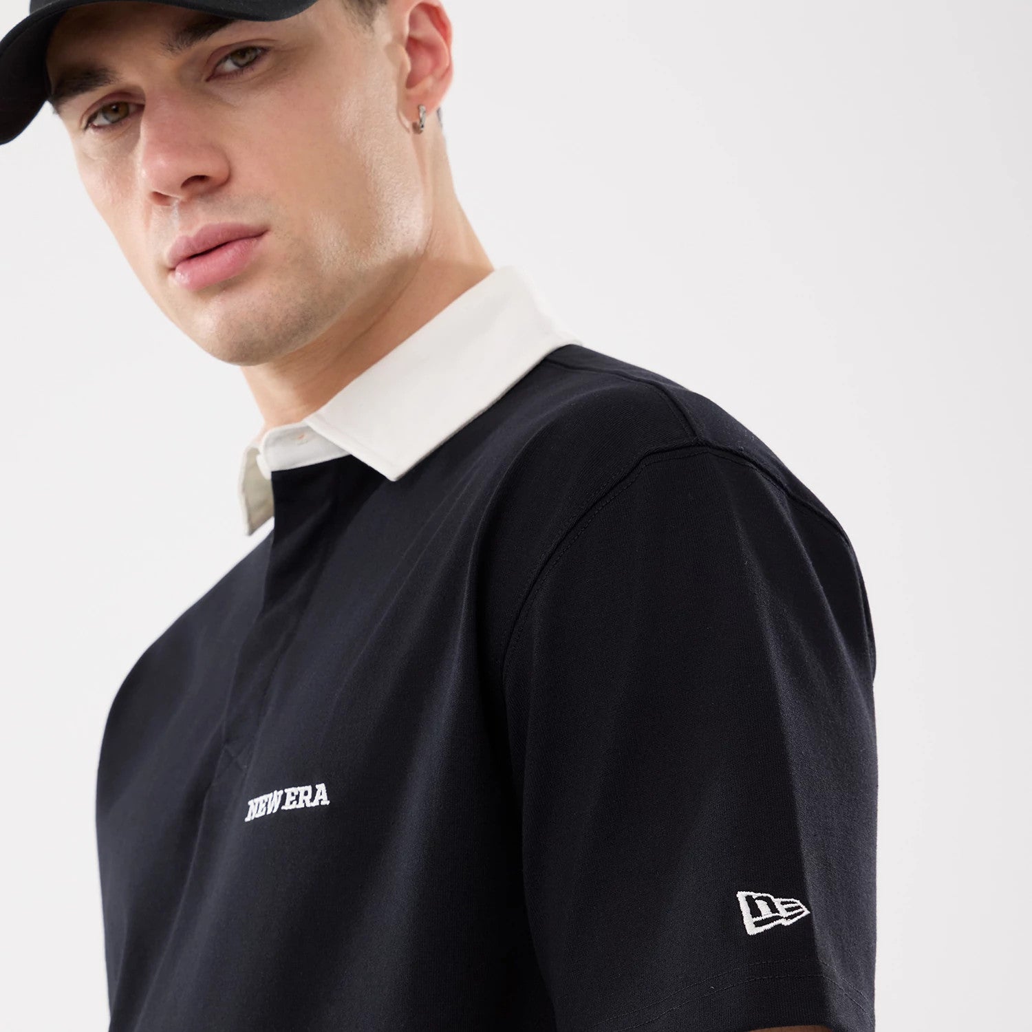 The model is wearing this New Era Short Sleeve Rugby Shirt in black. 5