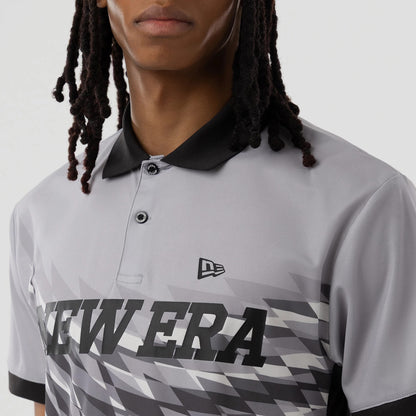 New Era Grid Grey Polo T-Shirt, front view showing a grey geometric pattern, a small raised New Era logo on the chest, and the large black “NEW ERA” text across the front, with a black collar featuring two buttons.