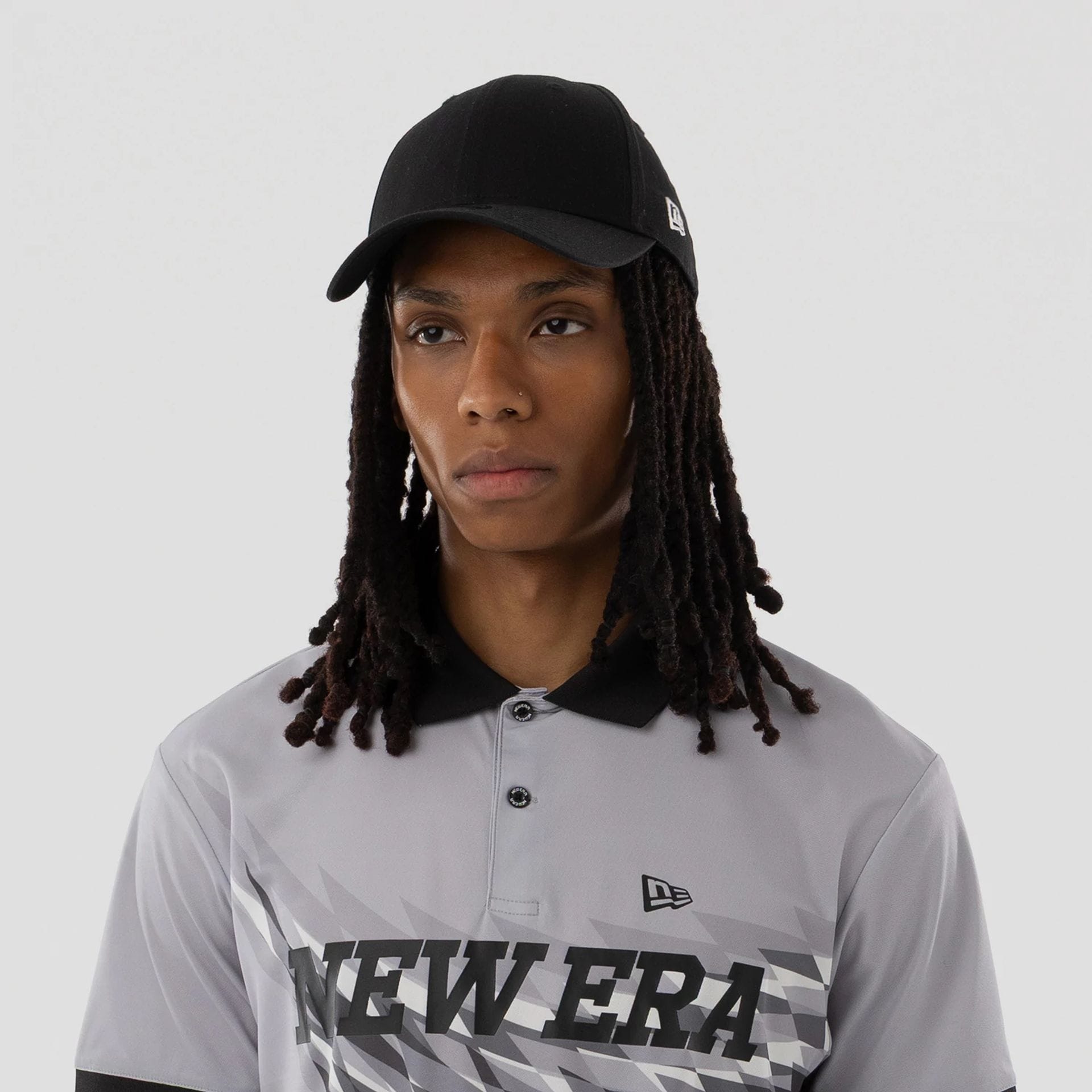 The model is wearing this New Era Grid Polo T-Shirt in grey. 4