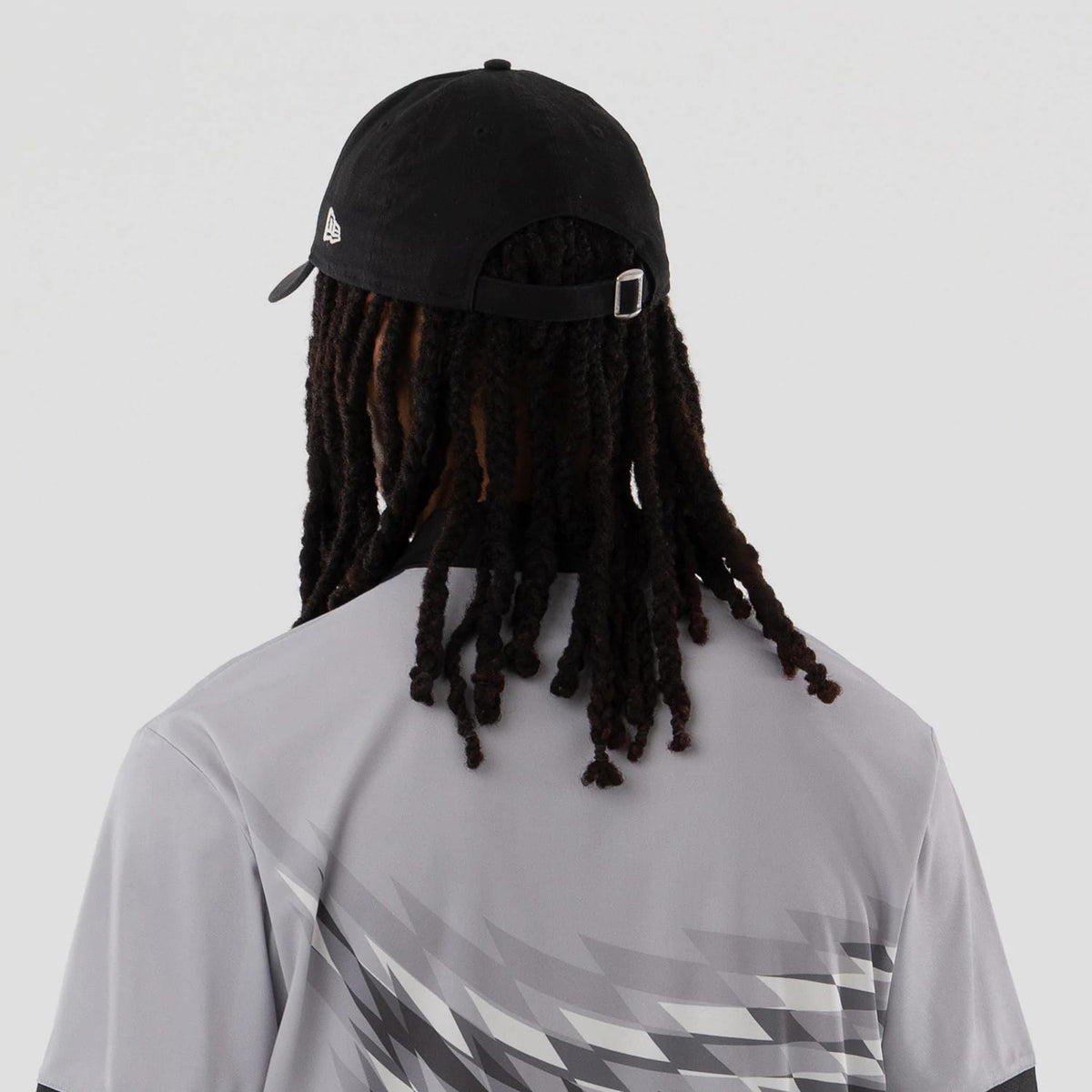 The model is wearing this New Era Grid Polo T-Shirt in grey. 7