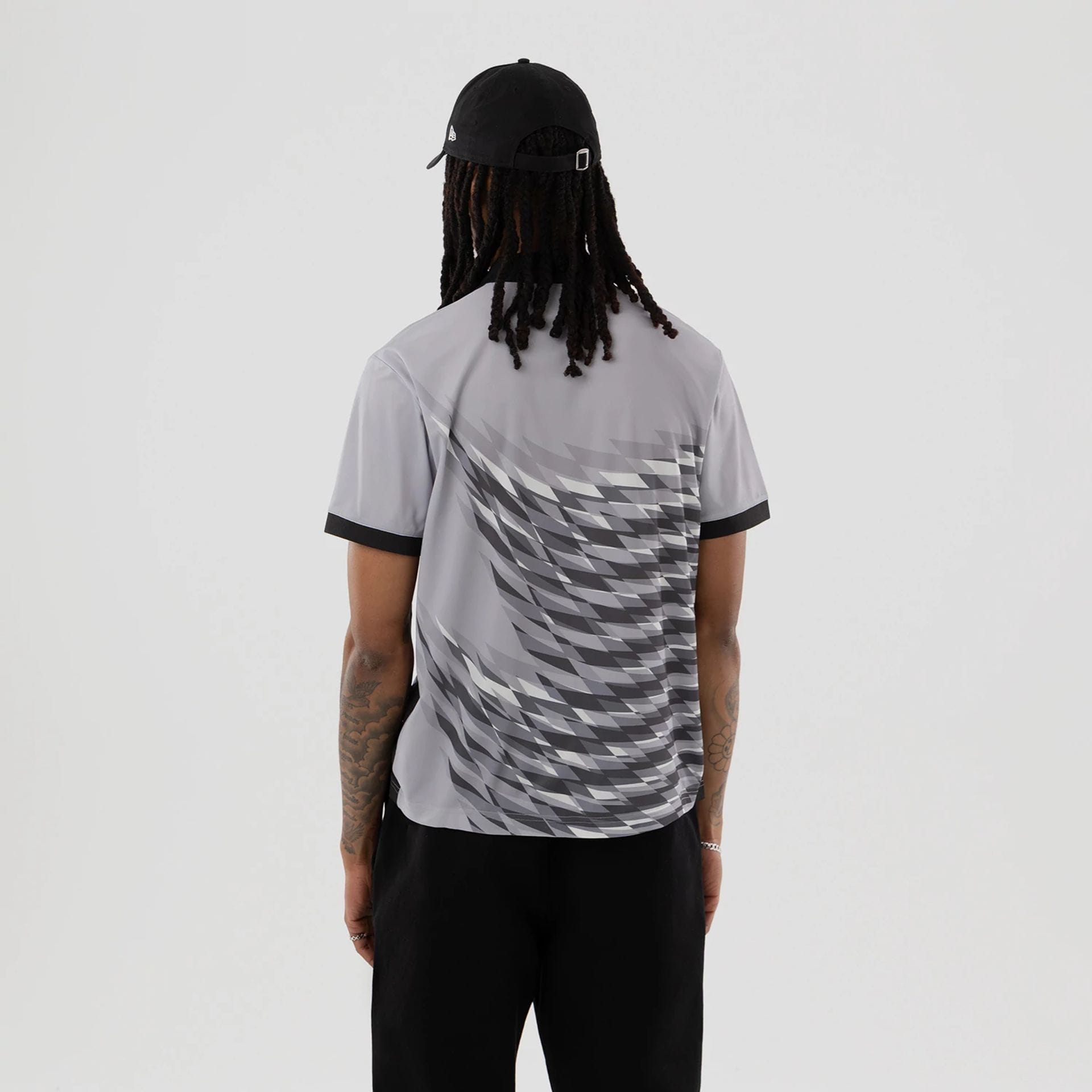 The model is wearing this New Era Grid Polo T-Shirt in grey. 2