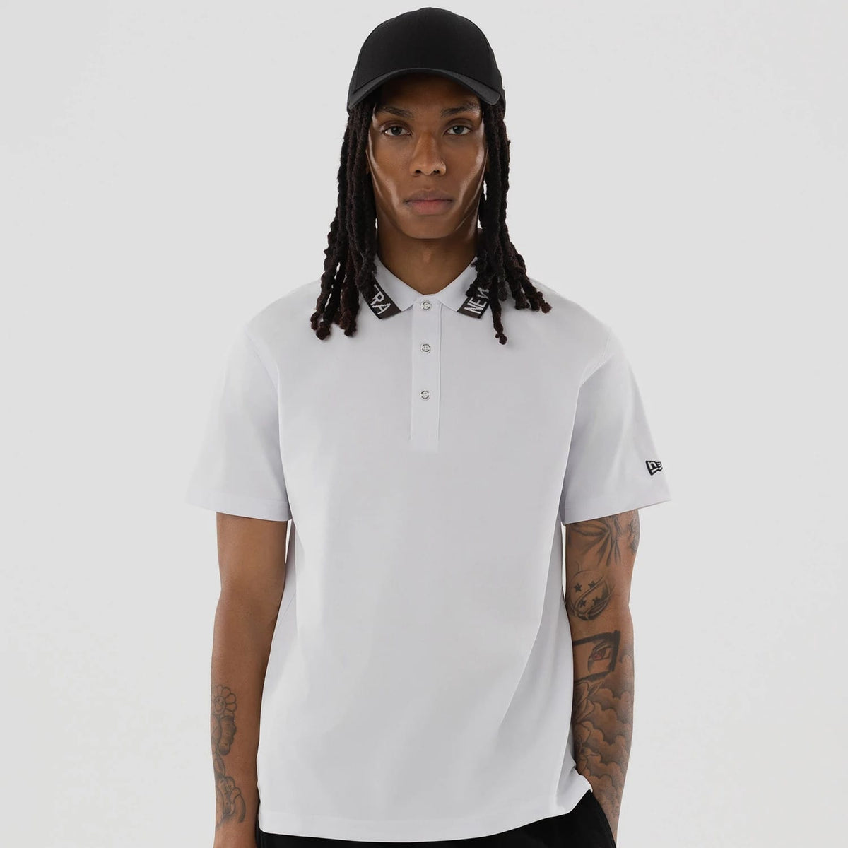 The model is wearing this New Era Kanoko Polo T-Shirt in white. 4