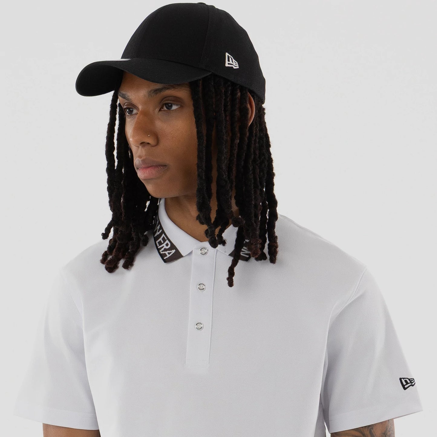 The model is wearing this New Era Kanoko Polo T-Shirt in white. 6
