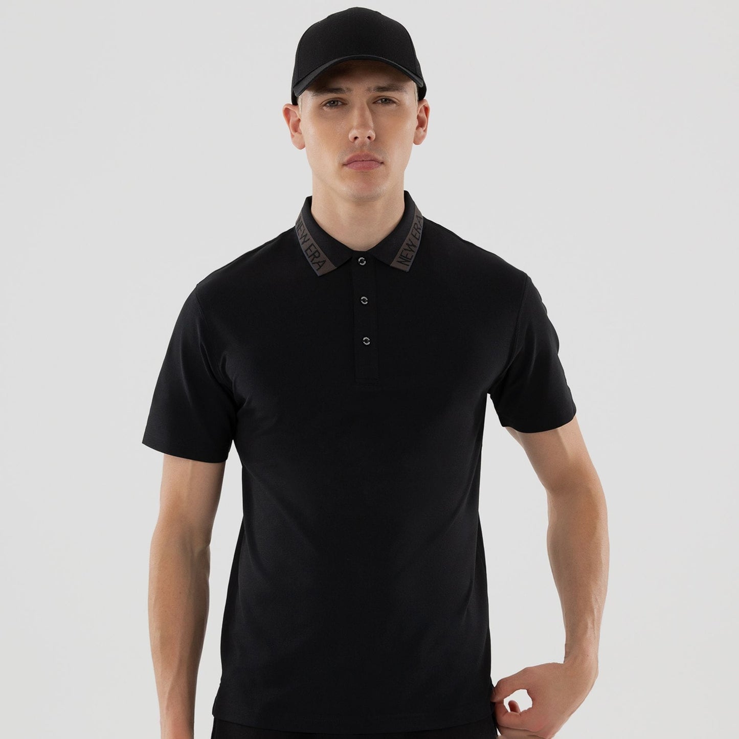 The model is wearing this New Era Kanoko Polo T-Shirt in black. 3