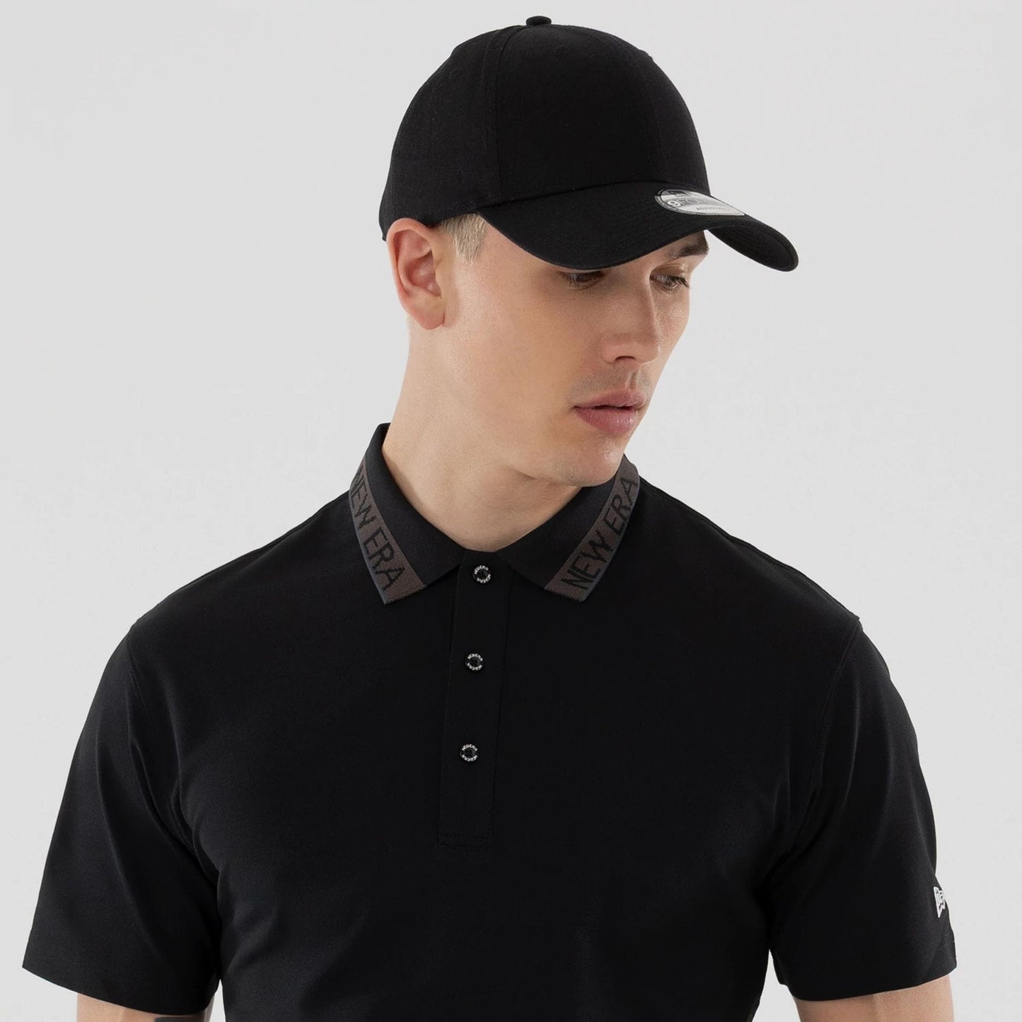 The model is wearing this New Era Kanoko Polo T-Shirt in black. 7