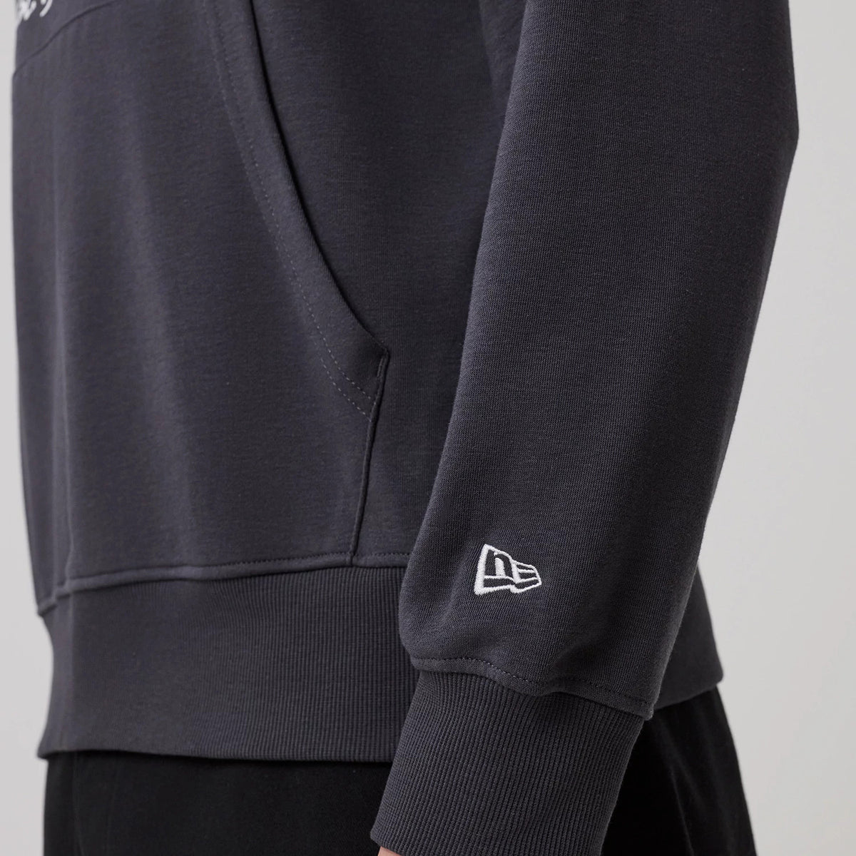 The model is wearing this New Era New York Oversized Pullover Hoodie in dark grey. 5