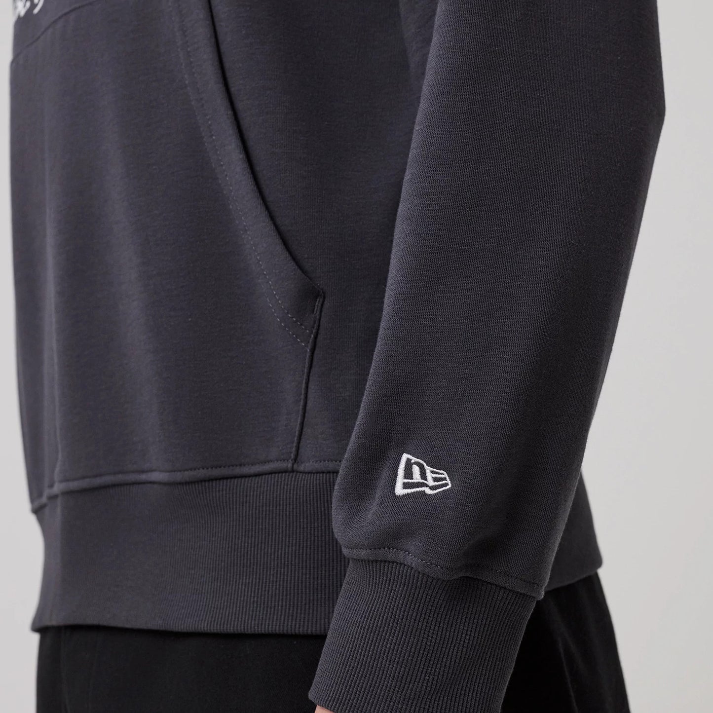The model is wearing this New Era New York Oversized Pullover Hoodie in dark grey. 5