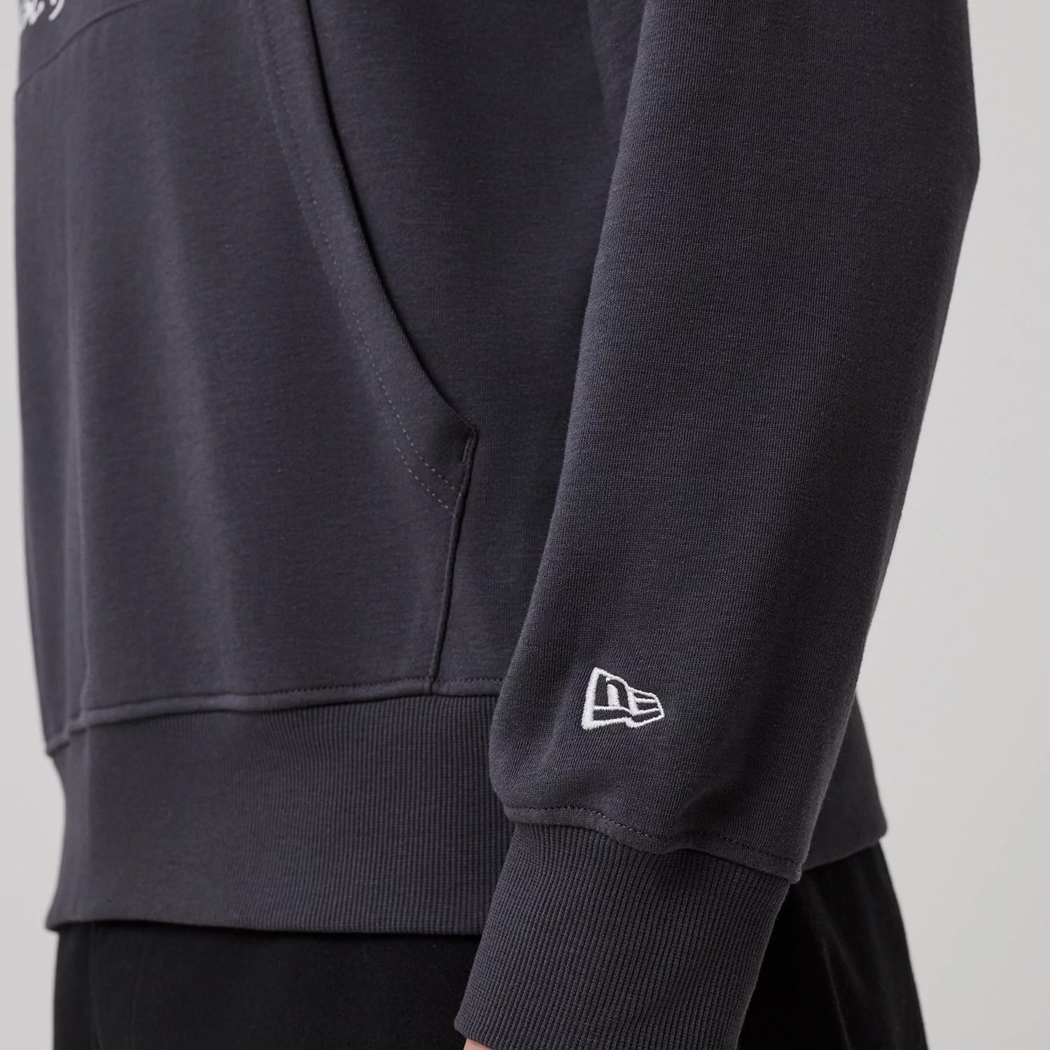 The model is wearing this New Era New York Oversized Pullover Hoodie in dark grey. 5
