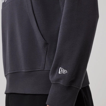 The model is wearing this New Era New York Oversized Pullover Hoodie in dark grey. 5